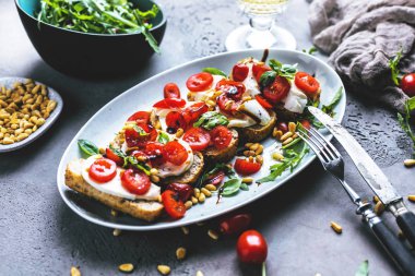 ızgara kabuklu ekmek, yakın çekim görünümü üzerinde doğranmış domates, fesleğen ve mozzarella ile İtalyan bruschetta