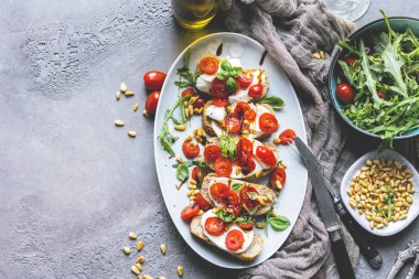 Doğranmış domates, fesleğen ve mozzarella ızgara kabuklu ekmek, üst görünümü ile İtalyan bruschetta