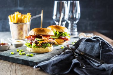 gemide taze lezzetli burger ve ahşap masada patates kızartması yakın çekim görünümü