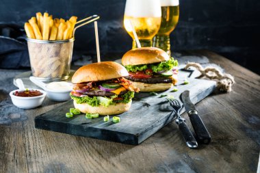 taze lezzetli burger, bira ve patates kızartması masanın üzerinde ahşap yakın çekim görünümü