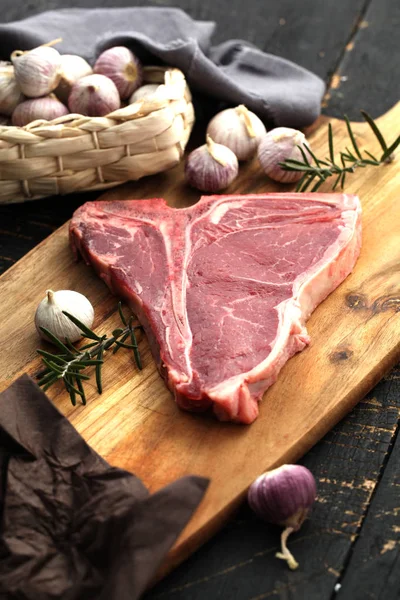 Rauwe T-Bone steak gekruid met kruiden en verse kruiden geserveerd op — Stockfoto