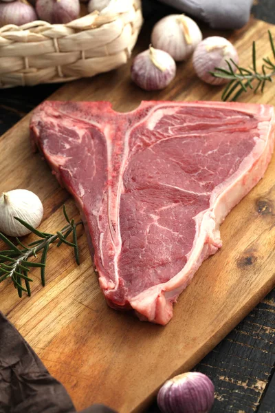 Rauwe T-Bone steak gekruid met kruiden en verse kruiden geserveerd op — Stockfoto