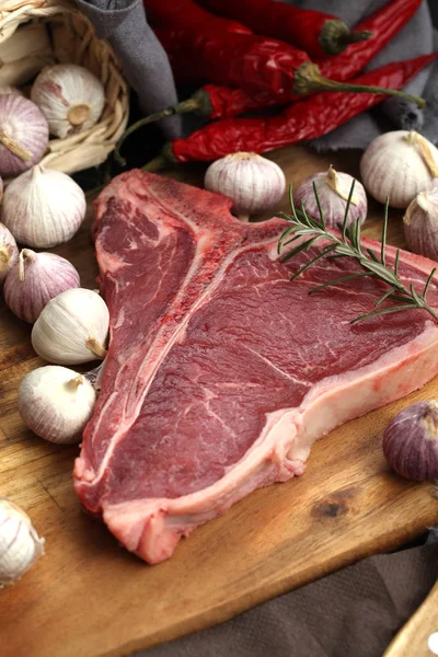 Rauwe T-Bone steak gekruid met kruiden en verse kruiden geserveerd op — Stockfoto