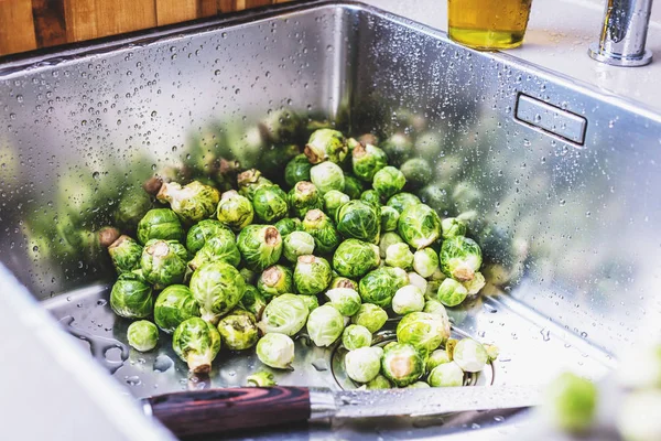 close-up view of raw Brussels sprouts washing in kitchen sink