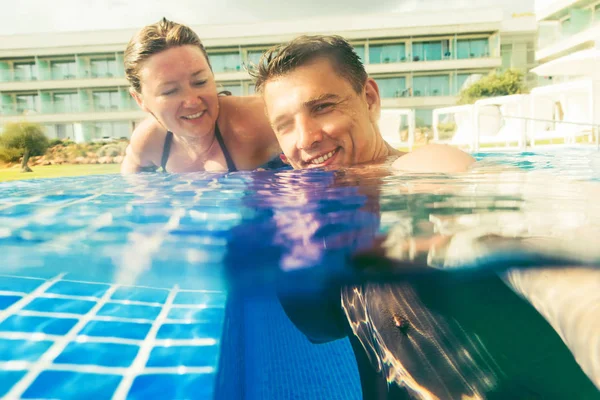 Yaz Tatilinde Yüzme Havuzunda Dinlenirken Kameraya Gülümseyen Neşeli Genç Çift — Stok fotoğraf