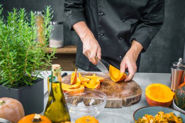 Erkek aşçının mutfakta taze, sağlıklı balkabakları hazırlarken çekilmiş bir fotoğrafı.