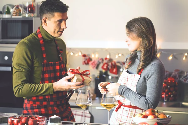 若い男は台所でクリスマスプレゼントで彼のガールフレンドを驚かせました — ストック写真