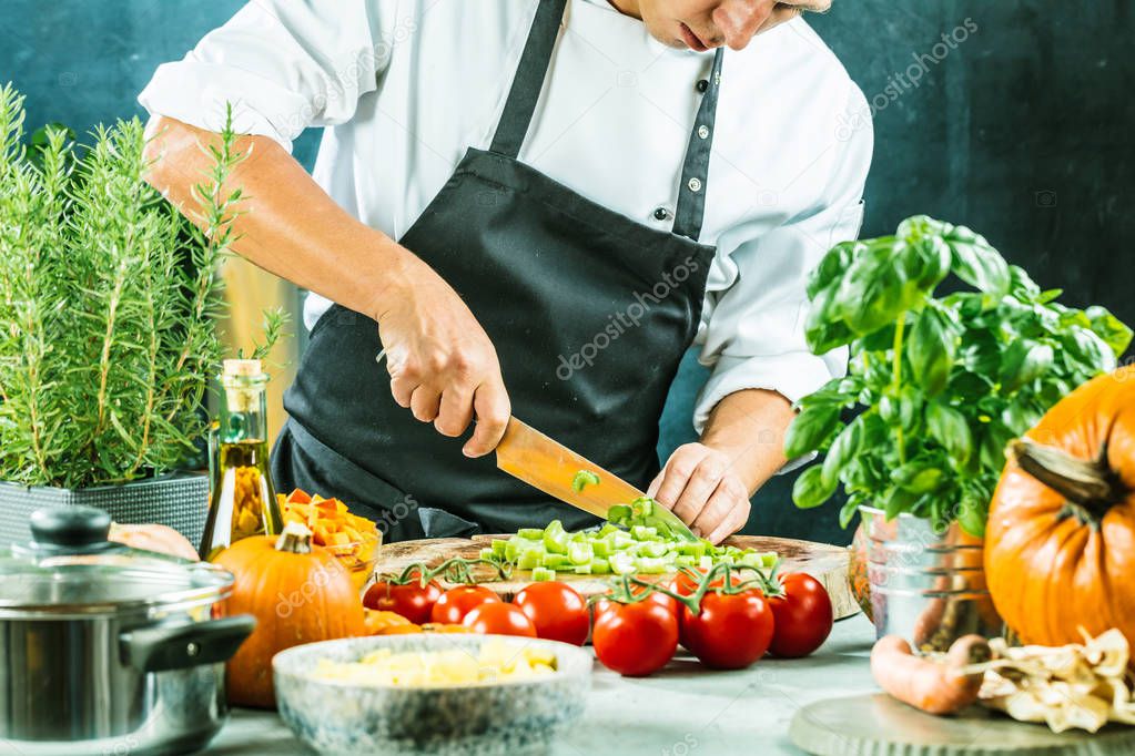 cropped shot of male chef chopping fresh vegetables