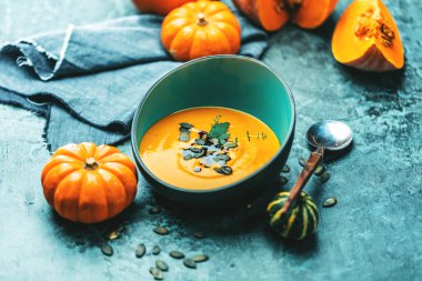 Kabak çorbasının yakın plan görüntüsü kabak püresi içinde tohumlar kasede ve kabaklar masada 
