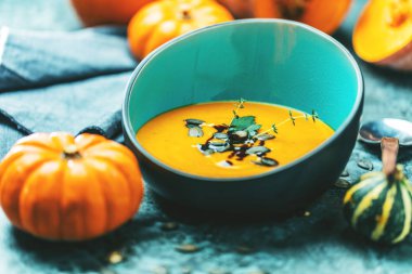 Kabak çorbasının yakın plan görüntüsü kabak püresi içinde tohumlar kasede ve kabaklar masada 