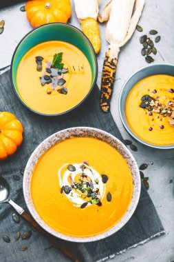 Sağlıklı kabak çorbası kaseler içinde püre, mısır ve kabaklar masada. 