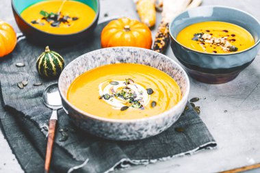 Kabak çorbasının yakın plan görüntüsü kaselerde püre, masada mısır ve balkabağı