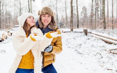 Mutlu genç çift kış ormanlarında birlikte vakit geçiriyor.