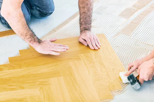 工人在家居改善过程中安装橡木地板的剪影 — 图库照片