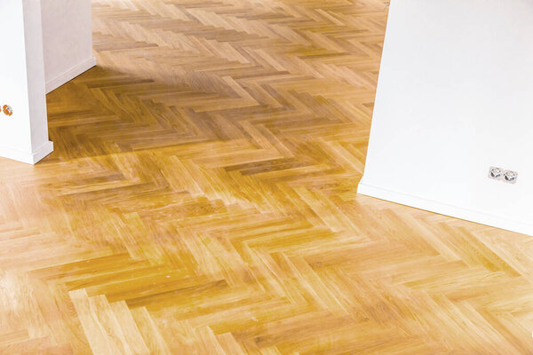 Interior of empty house with brown wooden parquet floor 