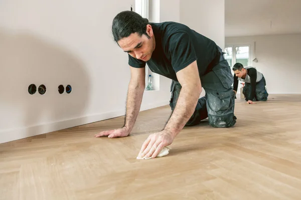 Trabalhadores Sexo Masculino Envernizando Piso Parquet Carvalho Durante Melhoria Casa — Fotografia de Stock