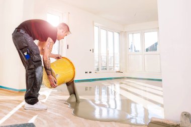 kendini tesviye çimento harcı ile çalışan zemin kaplama sı sırasında adam   