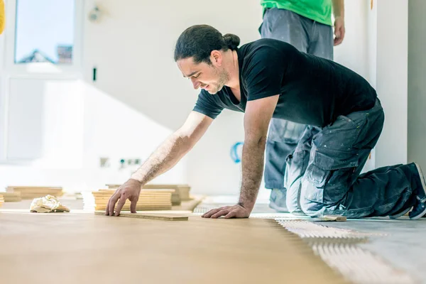 在家居改善过程中安装橡木地板的工人 — 图库照片