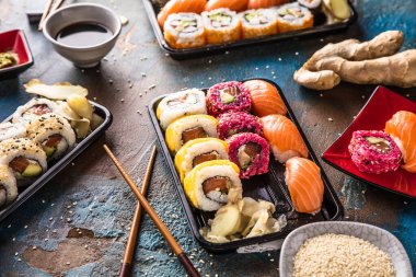 Gourmet geleneksel suşi seti zencefil, yemek çubukları ve soya sosu mavi ve kahverengi yüzeyde.