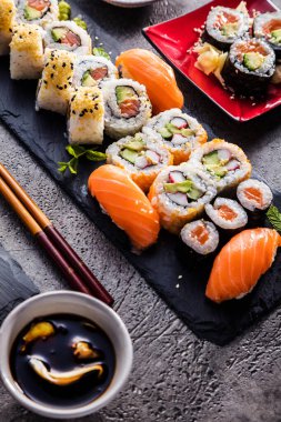 Yemek çubukları ve soya soslu lezzetli suşi setinin yakın plan görüntüsü.