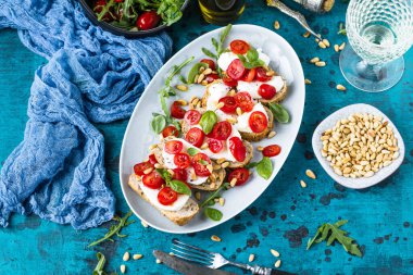 Çeri domatesli, roka ve mozzarella soslu nefis İtalyan bruschetta.