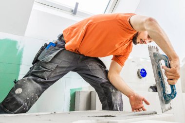 Erkek işçi inşaat alanına zemin kuruyor.