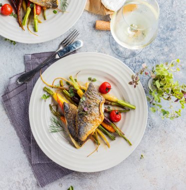 Beyaz tabakta sebzeli ızgara somon bifteği. 