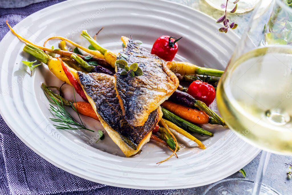 grilled fish with vegetables on white plate