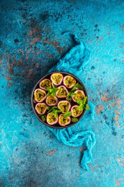 Mavi yüzeyde taze olgun, lezzetli tutku meyvelerinin üst görüntüsü.