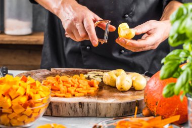 ... taze organik patatesleri soyan kişinin kısmi görüntüsü.