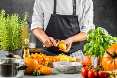 Şefin orta bölümü kabak çorbası için patates temizliyor. 