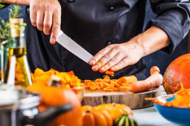 Kabak çorbası için havuç doğrayan şefin kısmi görüntüsü.