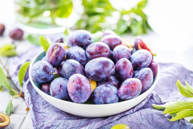 Masanın üzerinde organik erikler olan kasenin yakın görüntüsü.