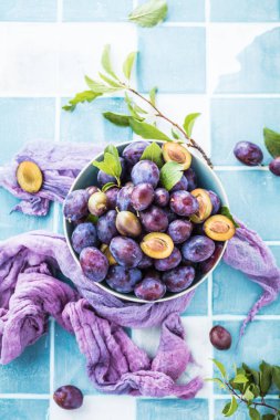 Masanın üzerinde taze organik erikler olan kasenin yakın görüntüsü.