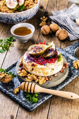 Meyve, fındık, bal, camembert peyniri, kuskus ve nar tohumlu ahşap masa.