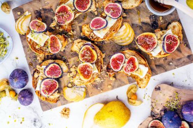 Taze kruvasan, incir, armut, fındık ve bal ile nefis bir kahvaltı manzarası.