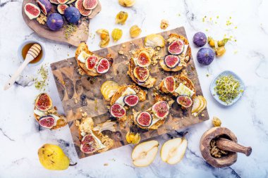 Taze kruvasan, incir, armut, fındık ve bal ile nefis bir kahvaltı manzarası.