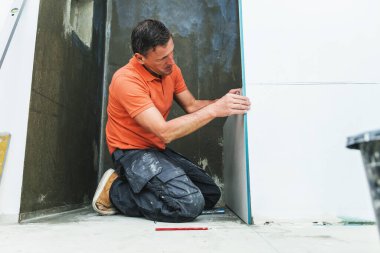 İşçi duvarlara büyük format döşemesi kuruyor. konut yenileme konsepti