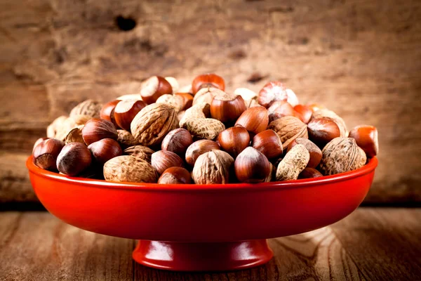 木のテーブルの上のボウルに健康的な有機物の様々なナッツのクローズアップビュー — ストック写真