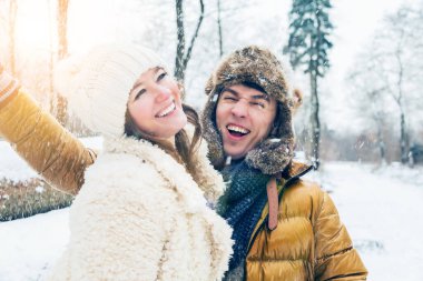 Güzel mutlu genç çift kış parkında birlikte eğleniyor.