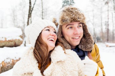 Güzel, neşeli genç çift birlikte vakit geçirip kış parkında eğleniyorlar.
