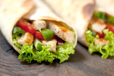 Tavuklu fajita sandviçleri ahşap masaya sarın.
