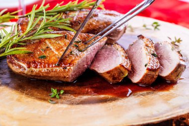 Şenlik masasında servis edilen baharatlı Noel ördeğinin yakın plan görüntüsü.