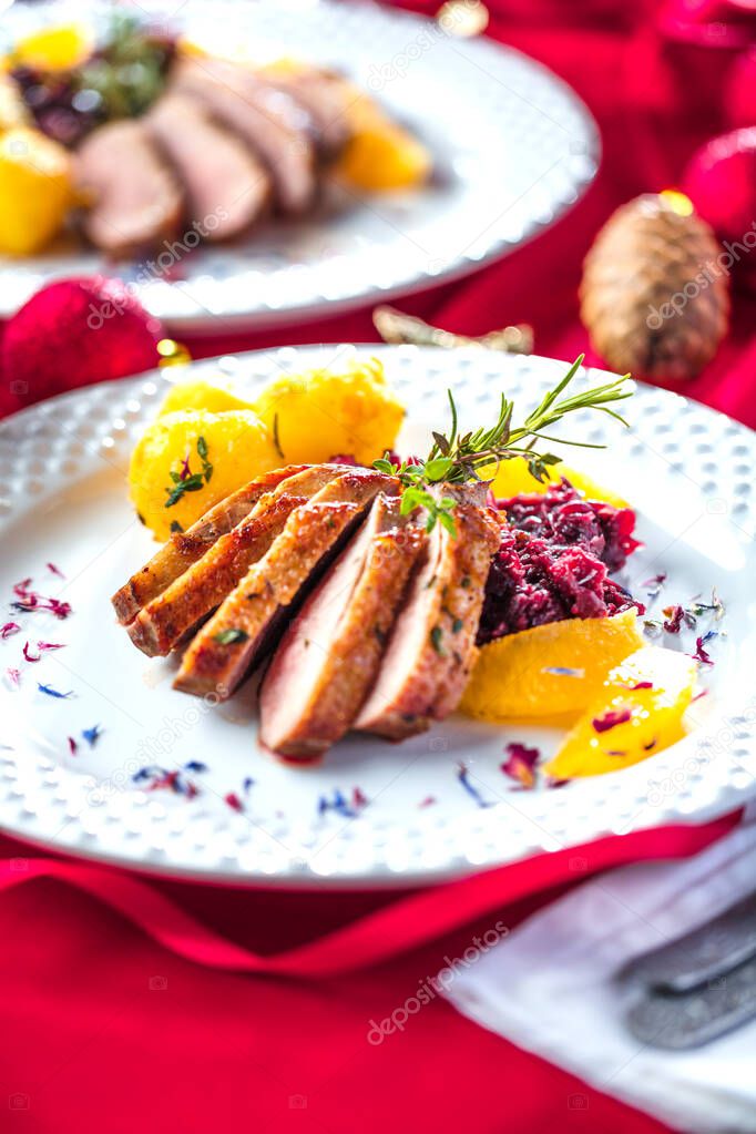 close-up view of delicious roasted duck breast with potatoes on festive table