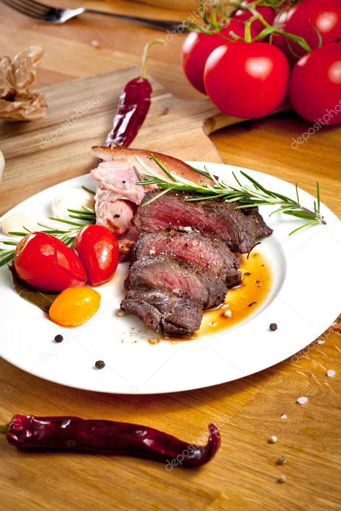delicious sliced grilled venison fillet on wooden table, close up