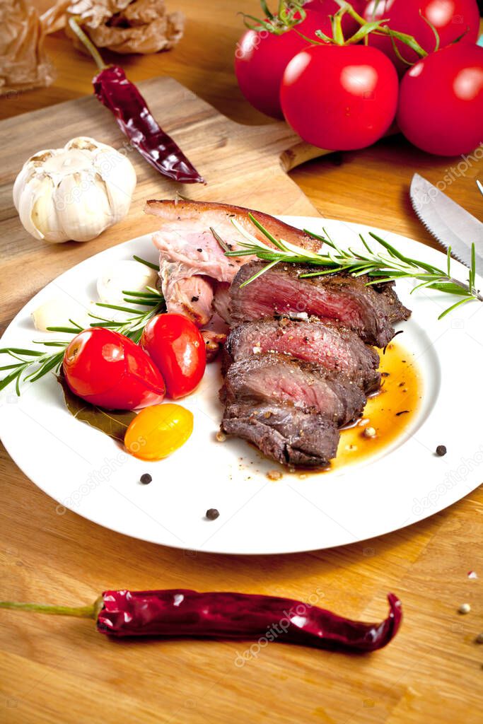 delicious sliced grilled venison fillet with spices, herbs and vegetables