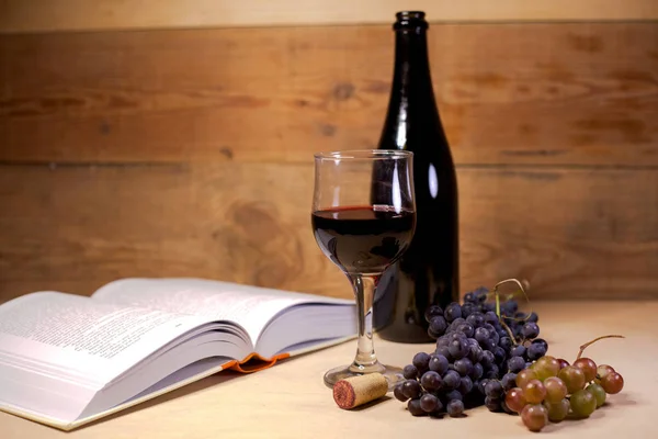 Açık Bir Kitap Üzüm Şişe Ile Kırmızı Şarap Bir Bardak — Stok fotoğraf