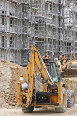 Ekskavatör inşaat alanında. Bina devam ediyor. Mimarisi. Dikey