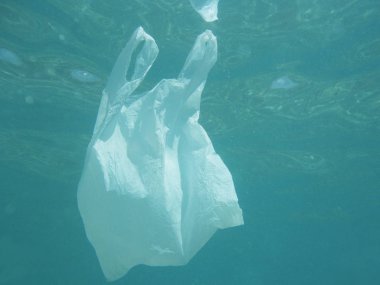 Plastic bag floating into the sea. Polluted environmental. Recycle garbage                    clipart