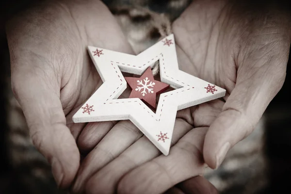 Handcrafted wooden christmas star. Love tenderness between elder — Stock Photo, Image